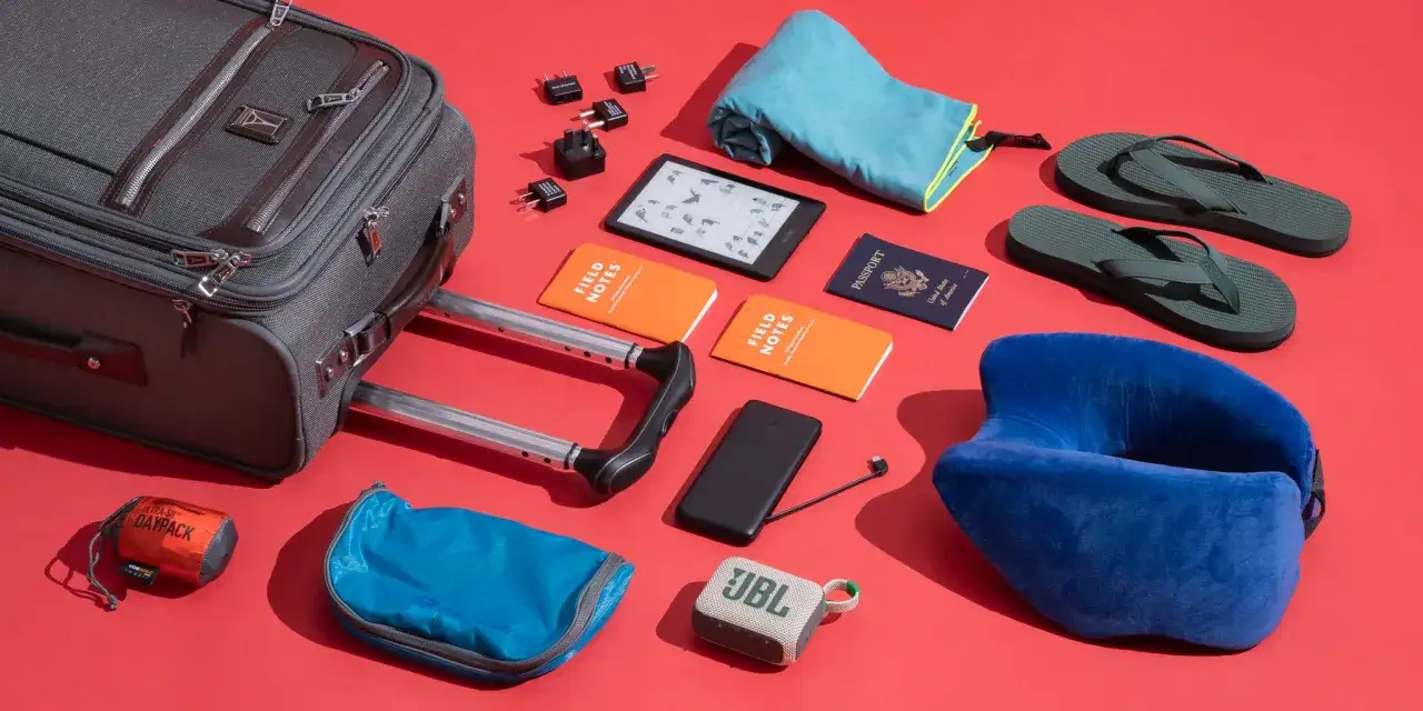 Walizka, paszport, notesy, Kindle, powerbank, adaptery i poduszka podróżna – wszystko gotowe na lot samolotem.