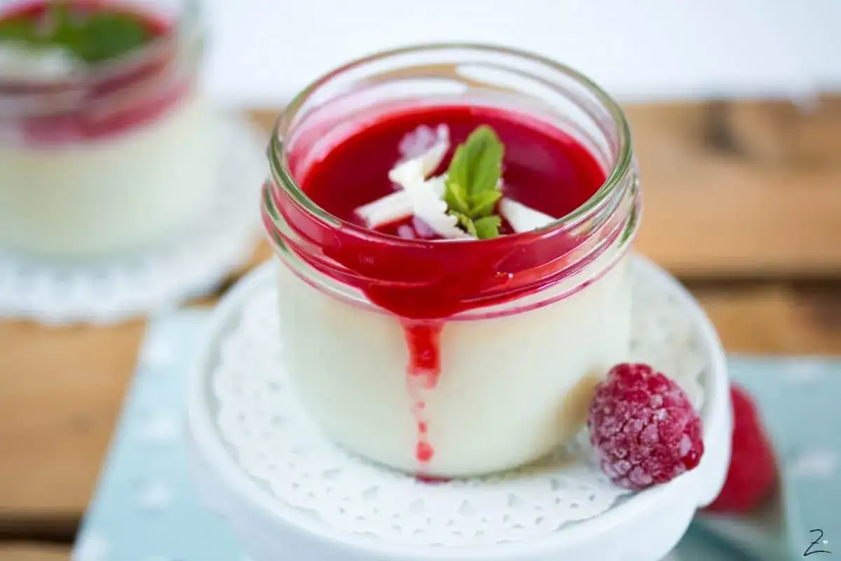 Panna Cotta im Glas, mit Himbeersoße und Minze garniert. Perfekt zubereitet mit dem Thermomix.