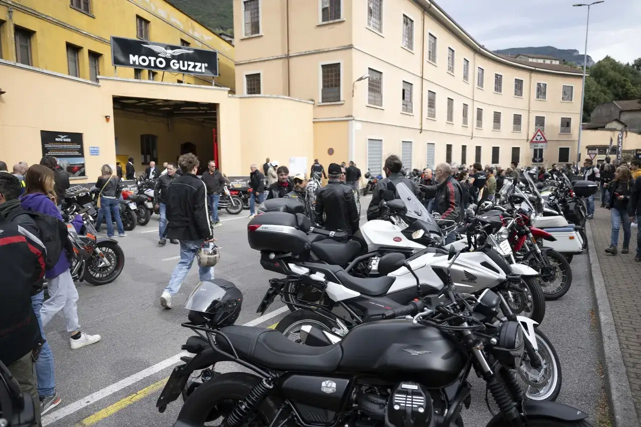 Un raduno Moto Guzzi con tanti appassionati e moto schierate davanti allo stabilimento.