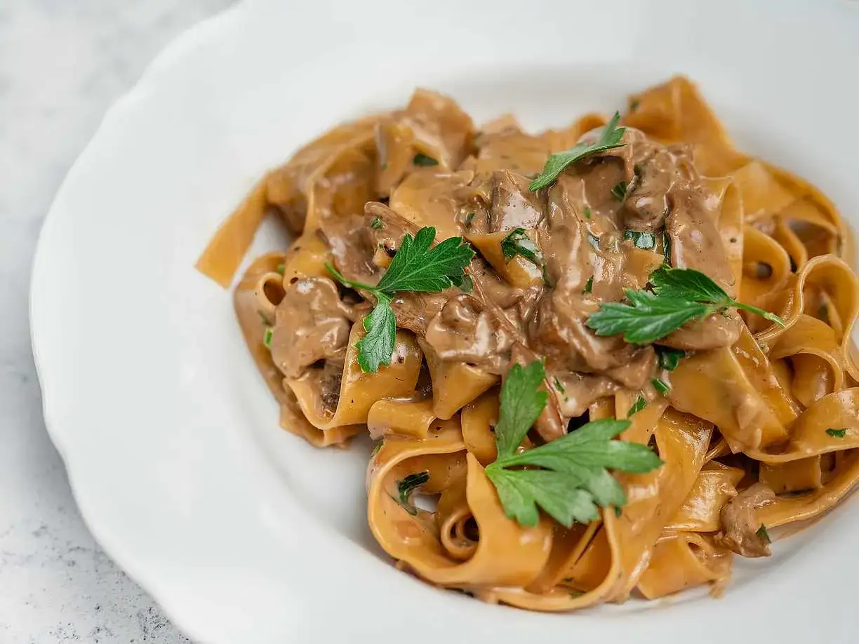 Krämig pasta med svamp, toppad med färsk persilja. En härlig pasta porcini som ser utsökt ut.