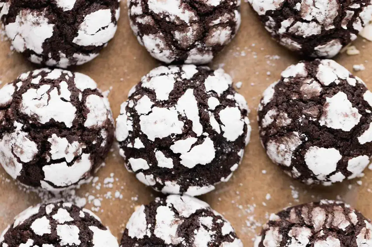 Mörka, spröda brownie cookies pudrade med florsocker, som små snöklädda berg.