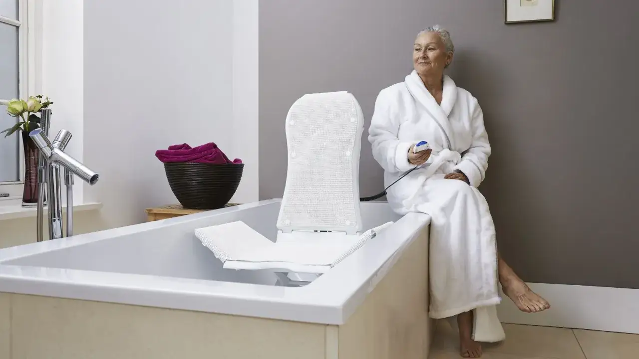 &Auml;ltere Dame mit Badewannenlifter schwenkbar, der von der Krankenkasse bezahlt wird, genie&szlig;t ein entspannendes Bad.