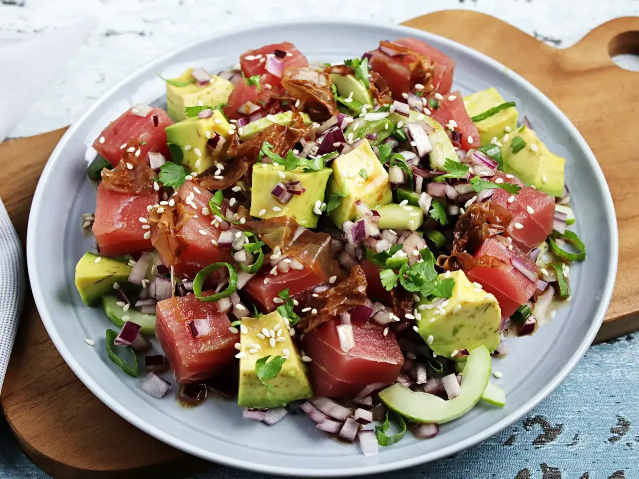 Frischer Thunfischsalat mit Avocado, roten Zwiebeln, Koriander und Sesam. Ein leichter und gesunder Genuss.