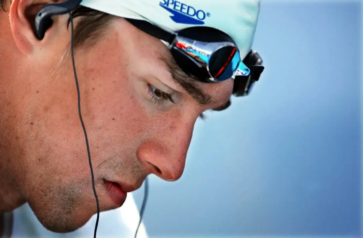 Michael Phelps visualization: a swimmer in goggles and cap, headphones in, focused before a race.