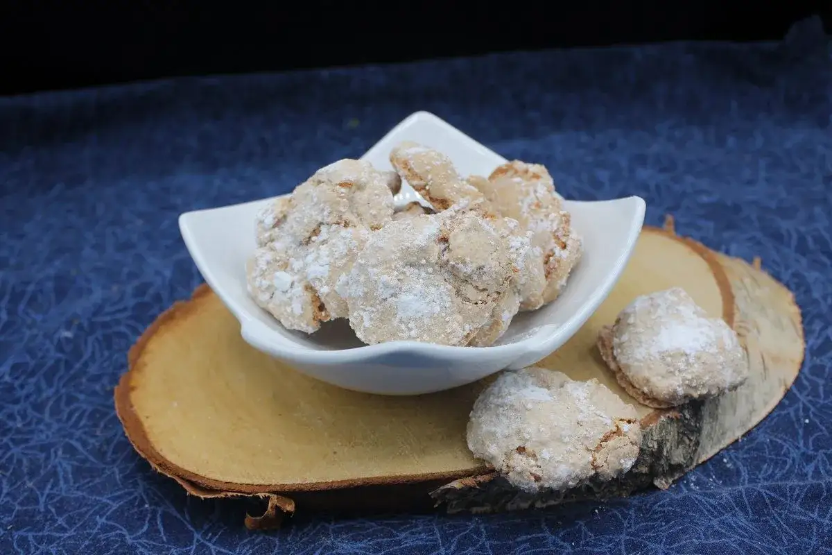 Amaretti saupoudrés de sucre glace, prêts à être dégustés. Une recette facile pour un plaisir gourmand.