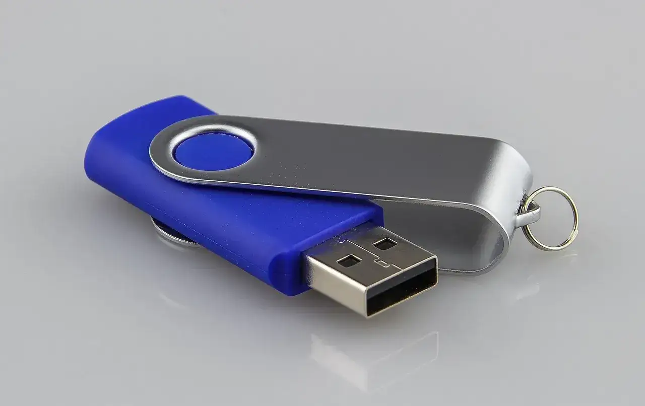 Niebieski pendrive z metalową obudową, idealny do przenoszenia prezentacji PowerPoint.