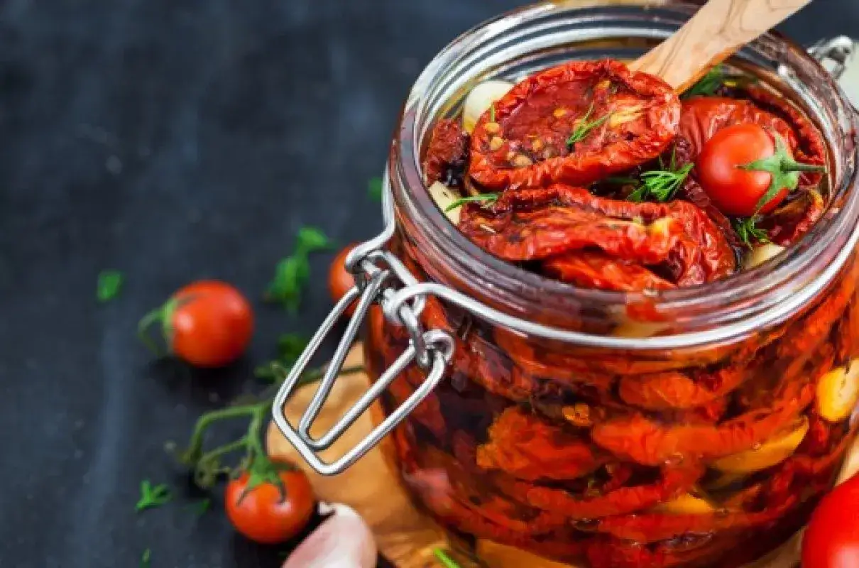 Słoik pełen aromatycznych pomidorów do słoików, z dodatkiem czosnku i ziół. Idealne na zimę!
