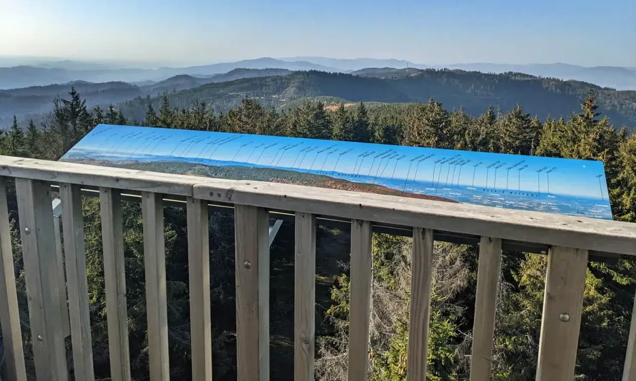 Widok z wieży widokowej na Beskid Sądecki. Szlak z Jaworek prowadzi na Radziejową, a tablica informacyjna pokazuje panoramę szczytów.