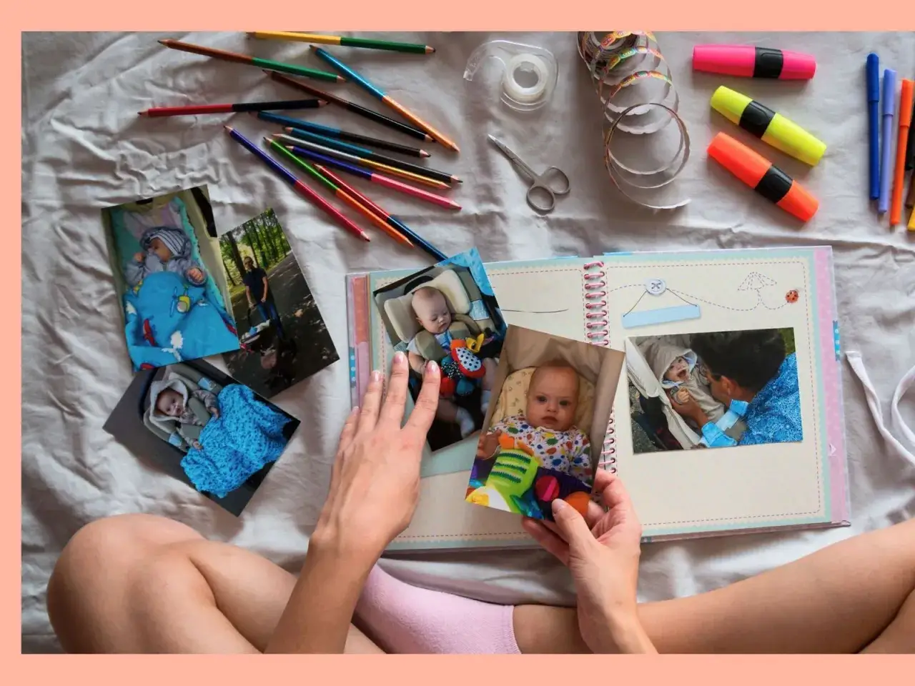 H&auml;nde gestalten ein Fotoalbum mit Babybildern, Buntstiften und Schere. Erinnerungen an Ferienerlebnisse Grundschule werden lebendig.
