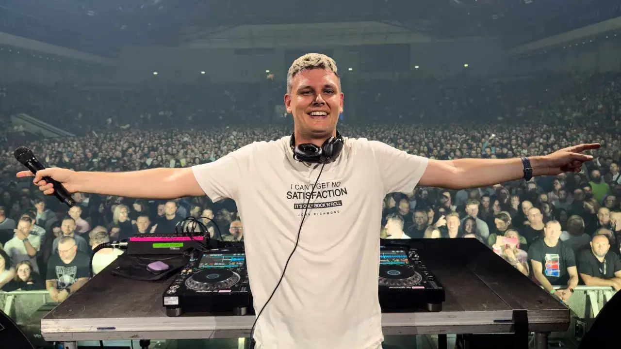 DJ Marcel Woods w białej koszulce z napisem