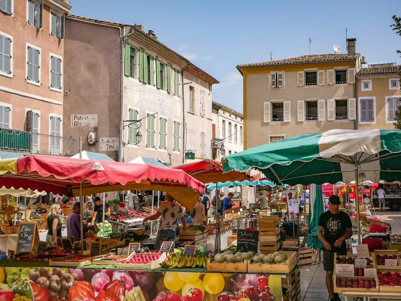 Animation color&eacute;e d'un march&eacute; proven&ccedil;al &agrave; Avignon, avec des &eacute;tals de fruits et l&eacute;gumes frais sous des parasols vifs.