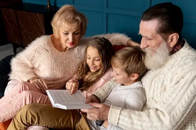 babcia i dziadek z wnukami czytają książkę
