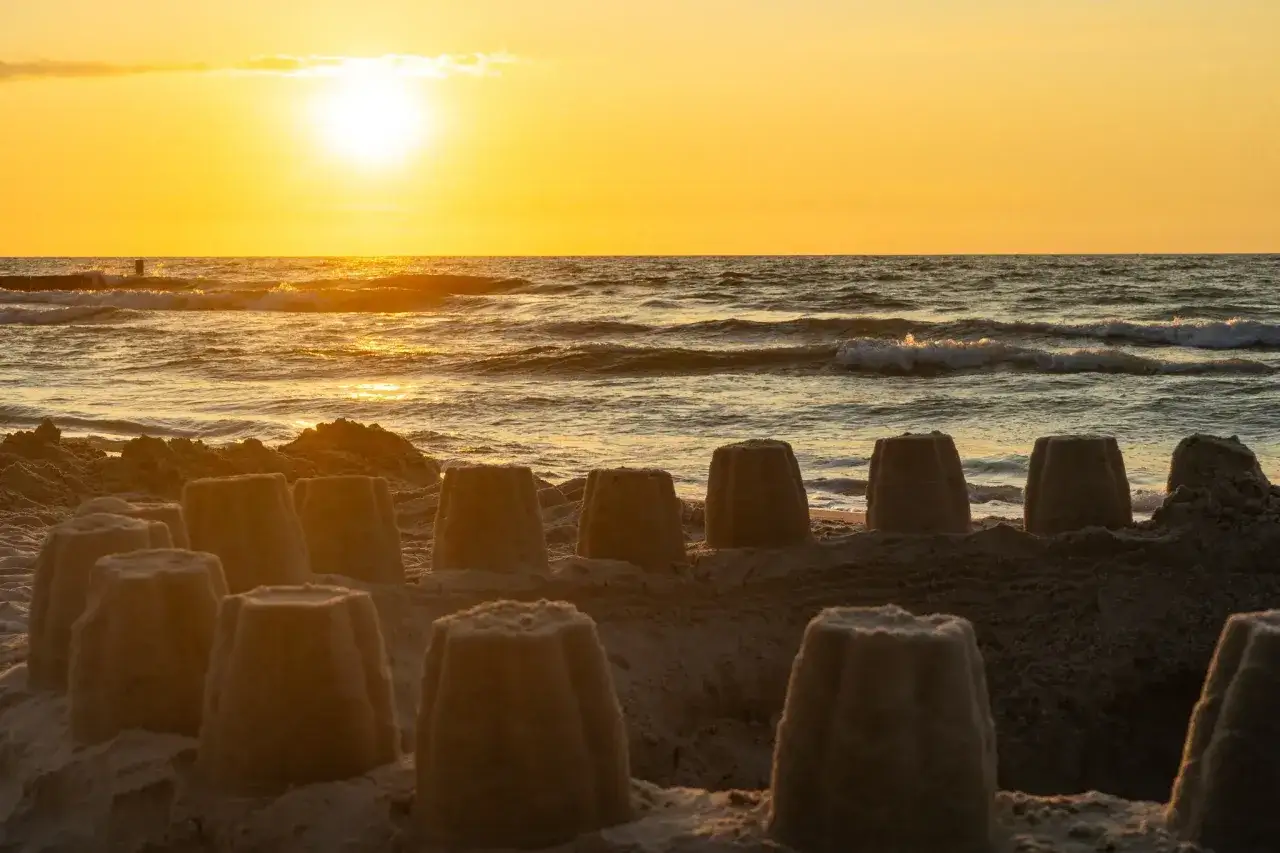 Piaskowe zamki na plaży, zachód słońca nad morzem. Sianożęty atrakcje dla dzieci i dorosłych.