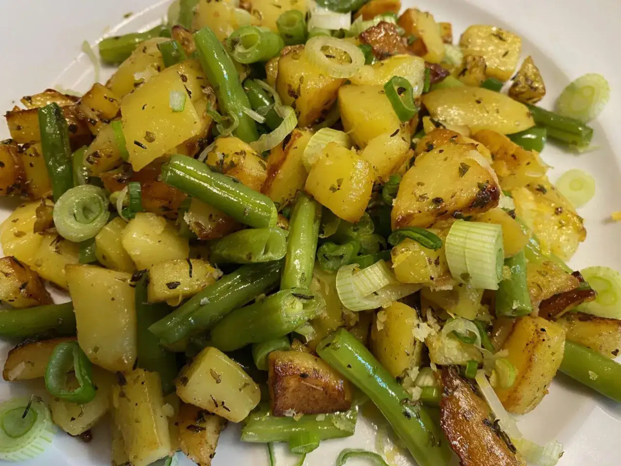 Herzhafte Kartoffel-Bohnen-Pfanne mit Frühlingszwiebeln, goldbraun gebraten und mit Kräutern verfeinert. Ein einfaches, leckeres Gericht.