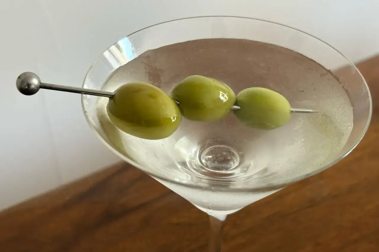 Klasyczny martini, wstrząśnięte nie zmieszane, z trzema oliwkami na wykałaczce. Idealny drink na wiecz&oacute;r.