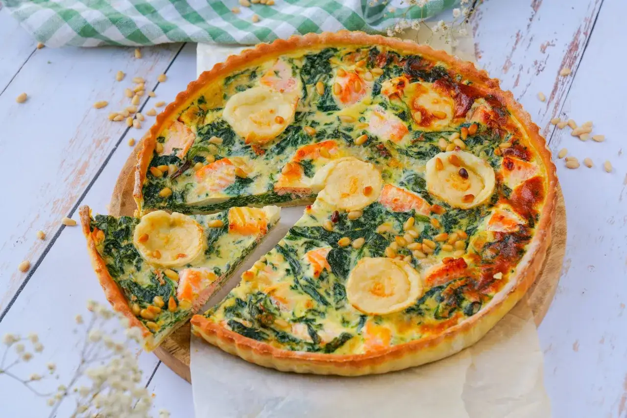 Une d&eacute;licieuse quiche saumon &eacute;pinard, garnie de pignons de pin et de rondelles de fromage de ch&egrave;vre, pr&ecirc;te &agrave; &ecirc;tre d&eacute;gust&eacute;e.