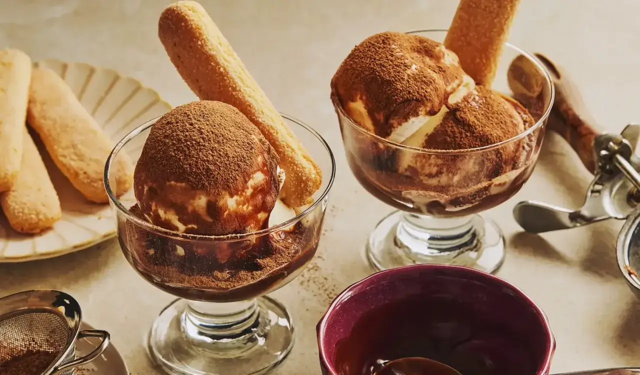 Deux coupes de glace tiramisu, saupoudr&eacute;es de cacao, avec des biscuits &agrave; la cuill&egrave;re.