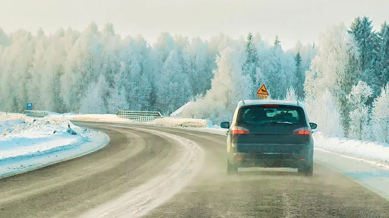 Bil k&ouml;r p&aring; sn&ouml;ig v&auml;g i frostig skog. Fr&aring;gan &auml;r om bensin fryser i s&aring;dana h&auml;r temperaturer.