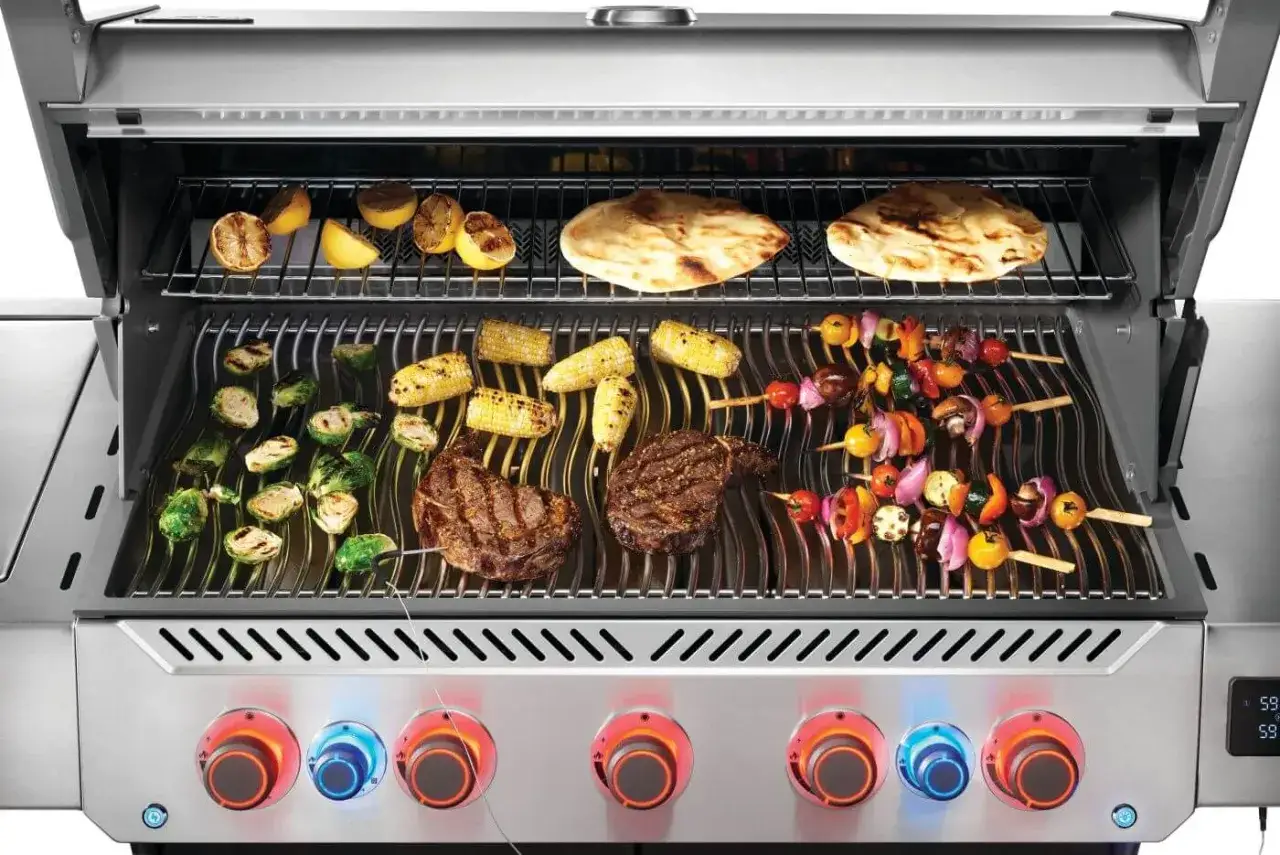 Grill gazowy w akcji: steki, szaszłyki warzywne, kukurydza, brukselka i cytryny na ruszcie. Pokazuje, jak działa grill gazowy, z podświetlanymi pokrętłami.