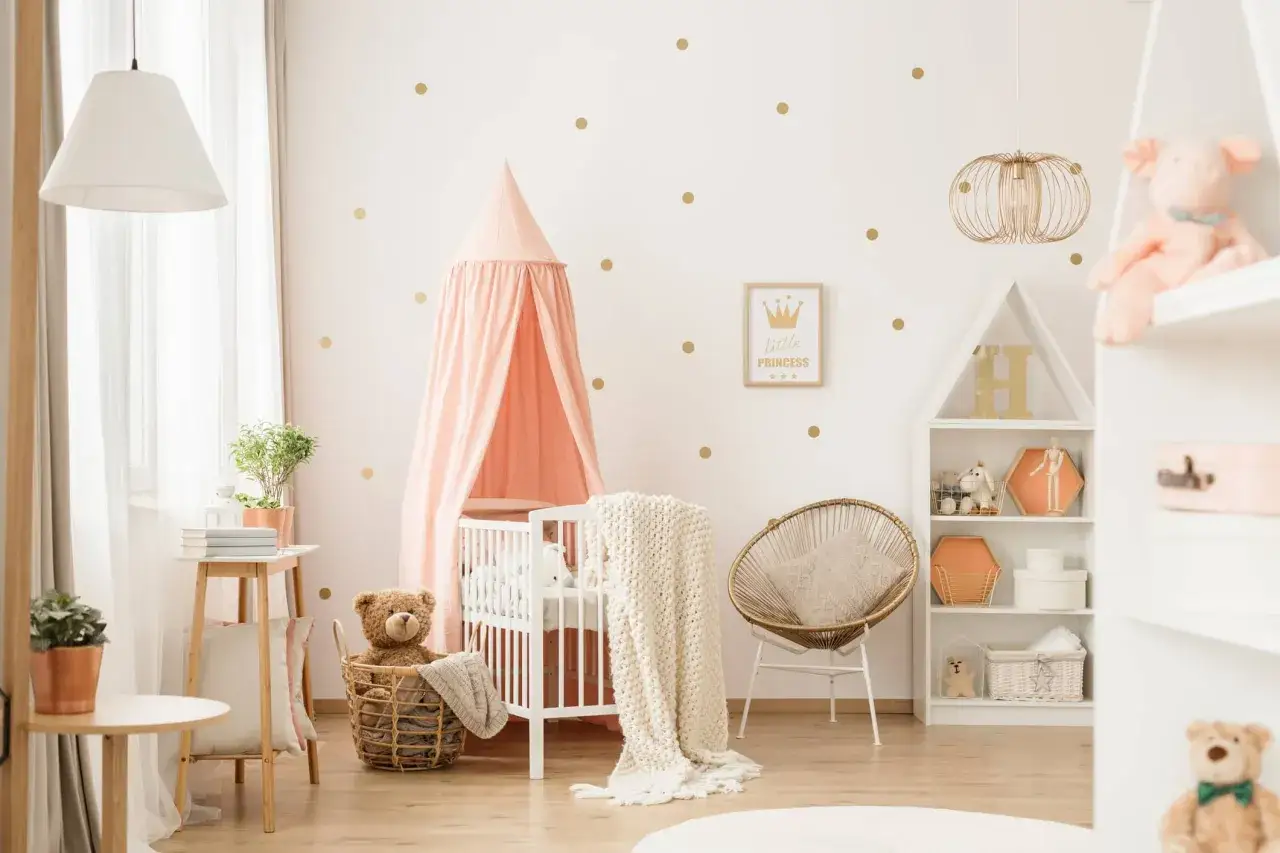 Stanza da sogno per un **settimino neonato**: culla rosa, orsacchiotto, decorazioni a pois dorati e un'atmosfera magica.