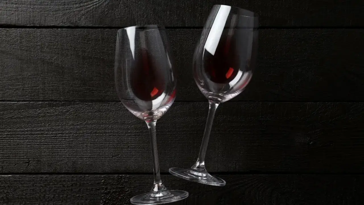 Due calici di vino rosso su fondo scuro. Un'immagine che evoca la ricerca della perfezione, ma anche la consapevolezza dei possibili difetti del vino.