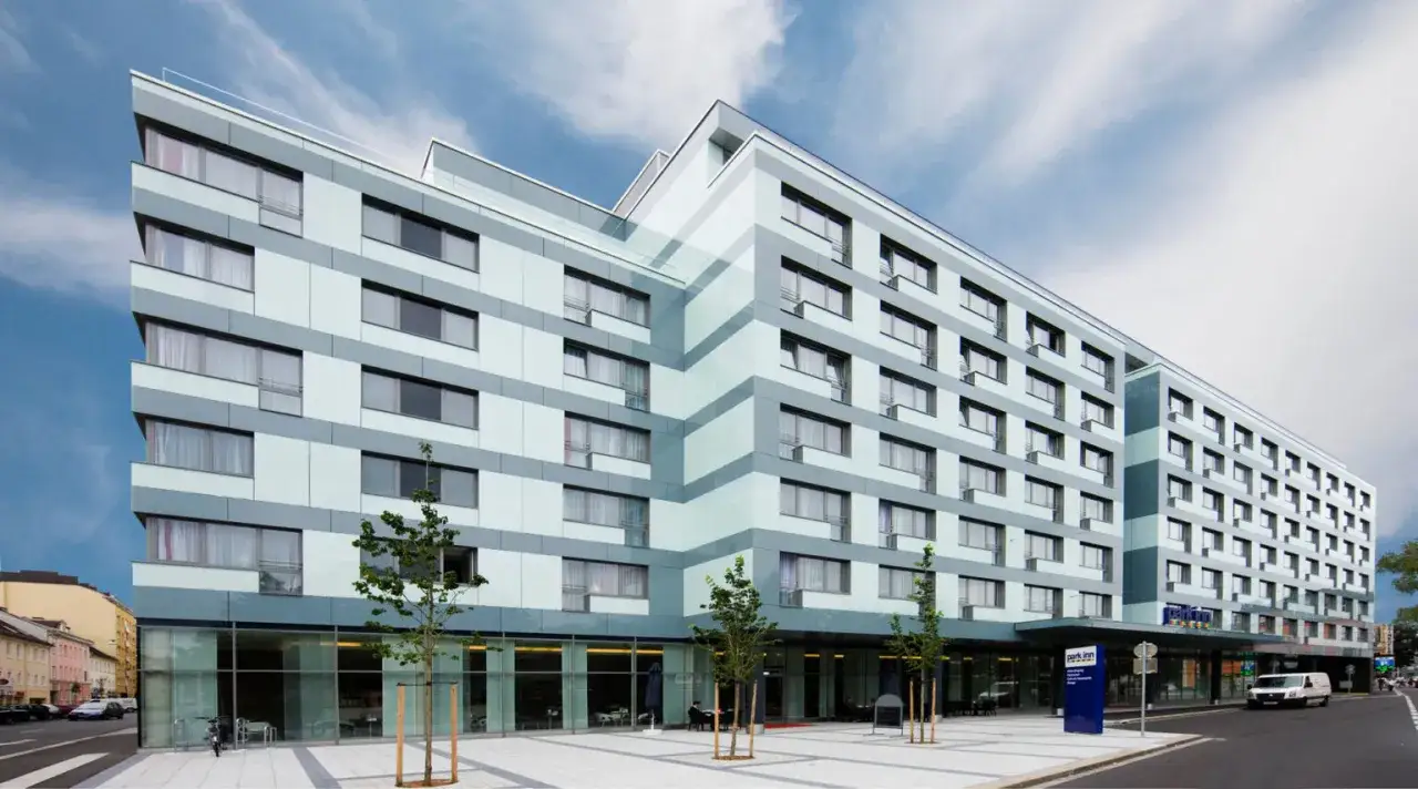 Modernes Hotelgebäude mit vielen Fenstern und einem blauen Schild mit der Aufschrift 