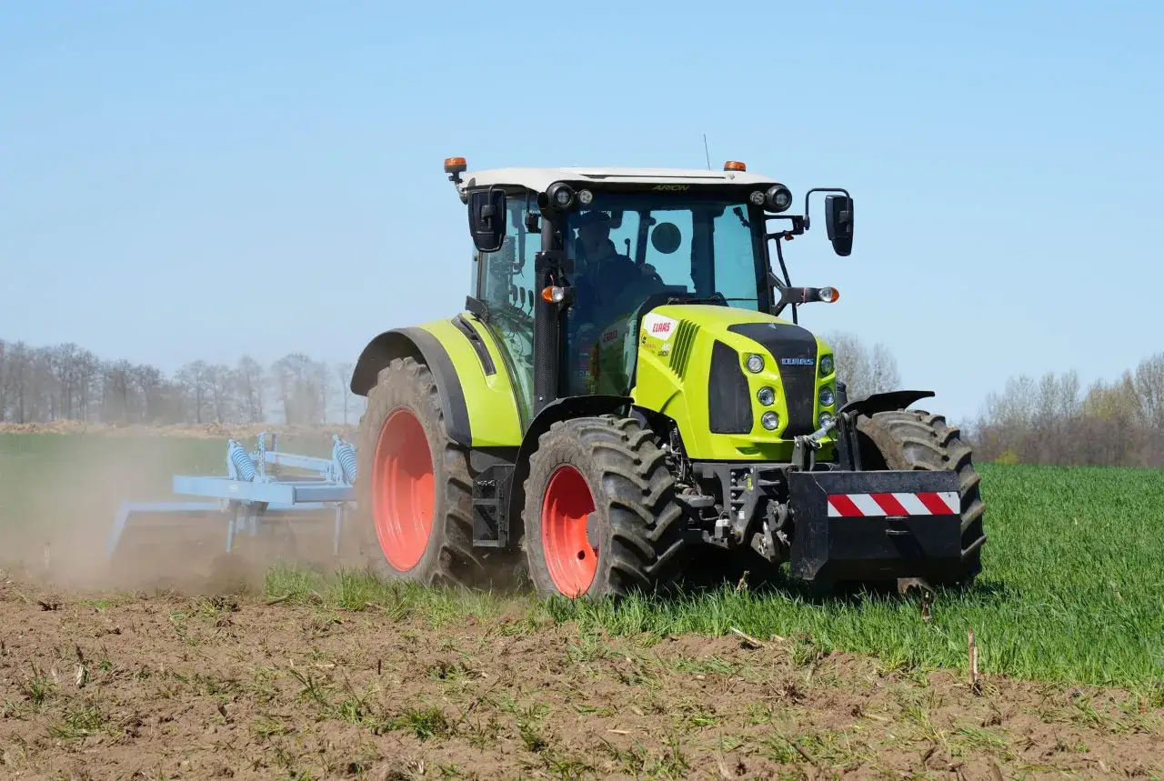 Ciągnik Claas Arion 430 z pługiem obracającym ziemię na polu.