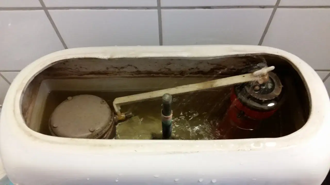 Insidan av en cistern fr&aring;n en Gustavsberg Nordic 2002 toalett, med synlig flott&ouml;r och mekanism.