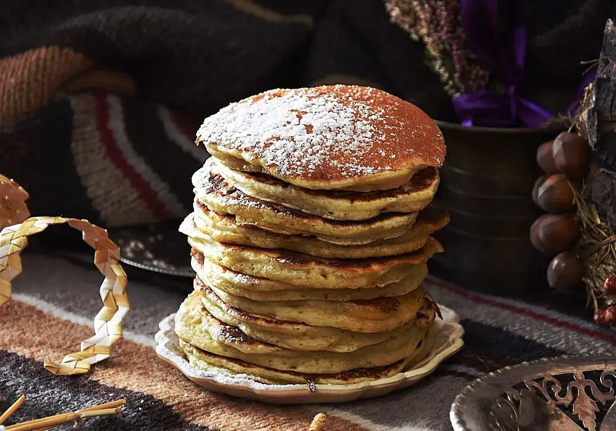 Montón de tortitas esponjosas espolvoreadas con azúcar glas, perfectas para tu próxima receta de tortitas.