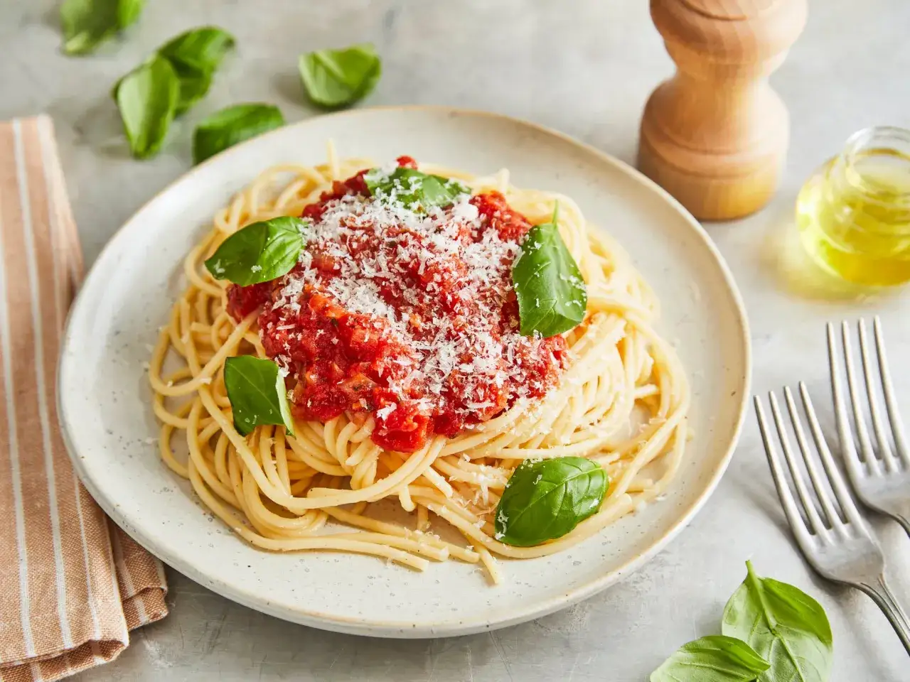 Ein Teller Spaghetti Napoli mit Tomatensauce, Parmesan und Basilikum.