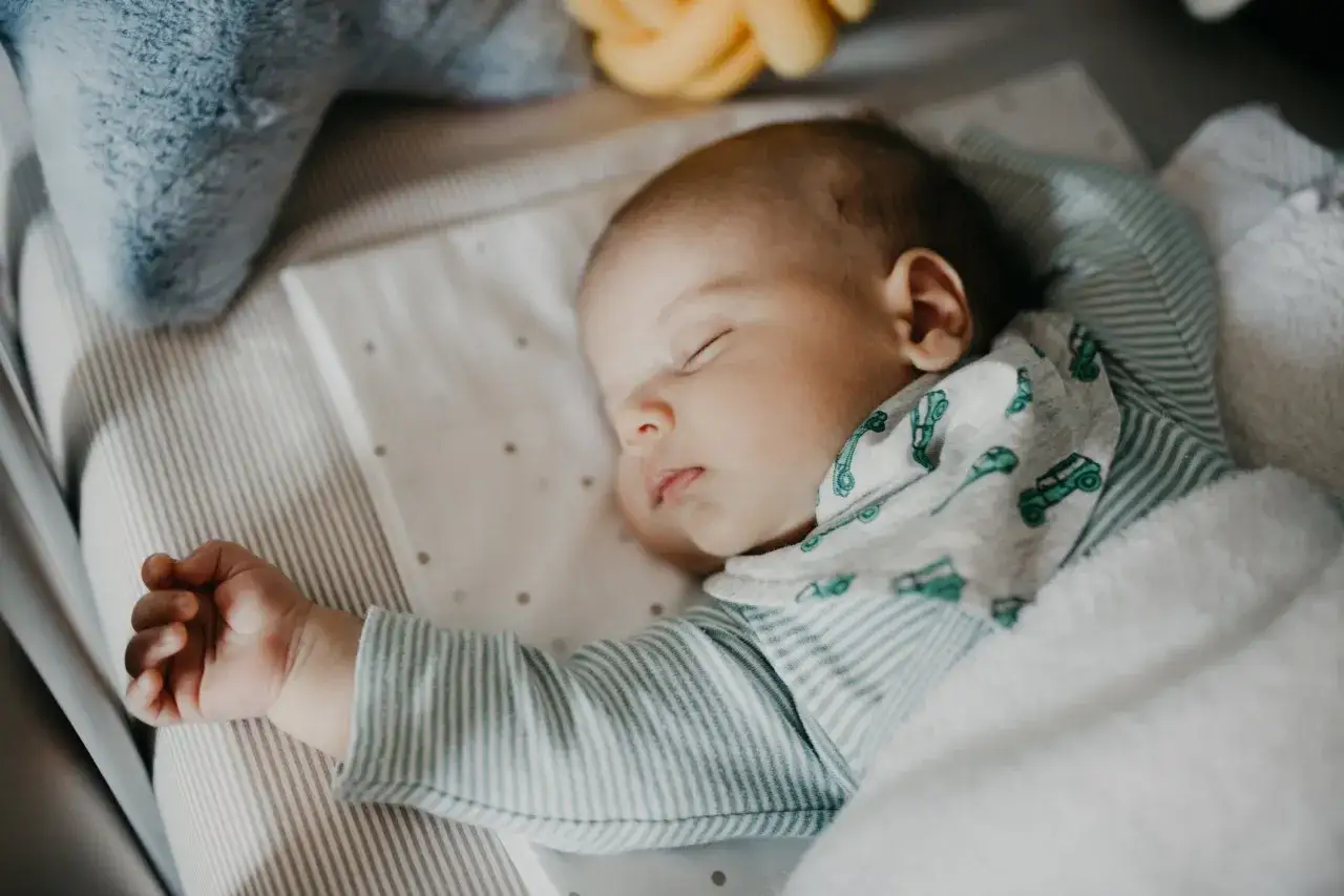 Un beb&eacute; duerme pl&aacute;cidamente en su cuna, envuelto en una manta. &iexcl;Qu&eacute; maravilla cuando un beb&eacute; duerme toda la noche!