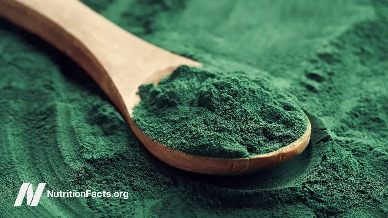 Zielony proszek na drewnianej łyżce. To spirulina, co to za superfood?