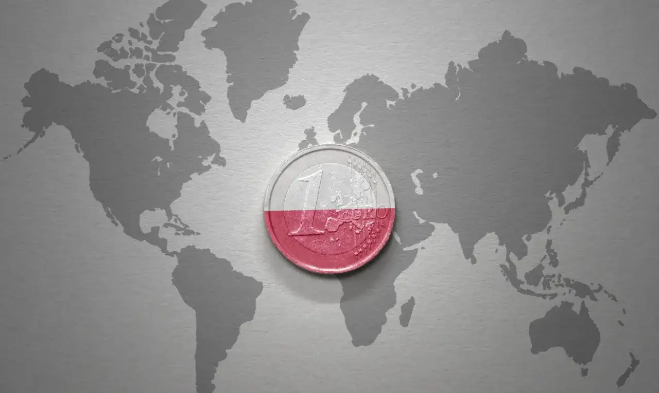 Moneta z polską flagą na tle mapy świata. Czy euro w Polsce to przyszłość?