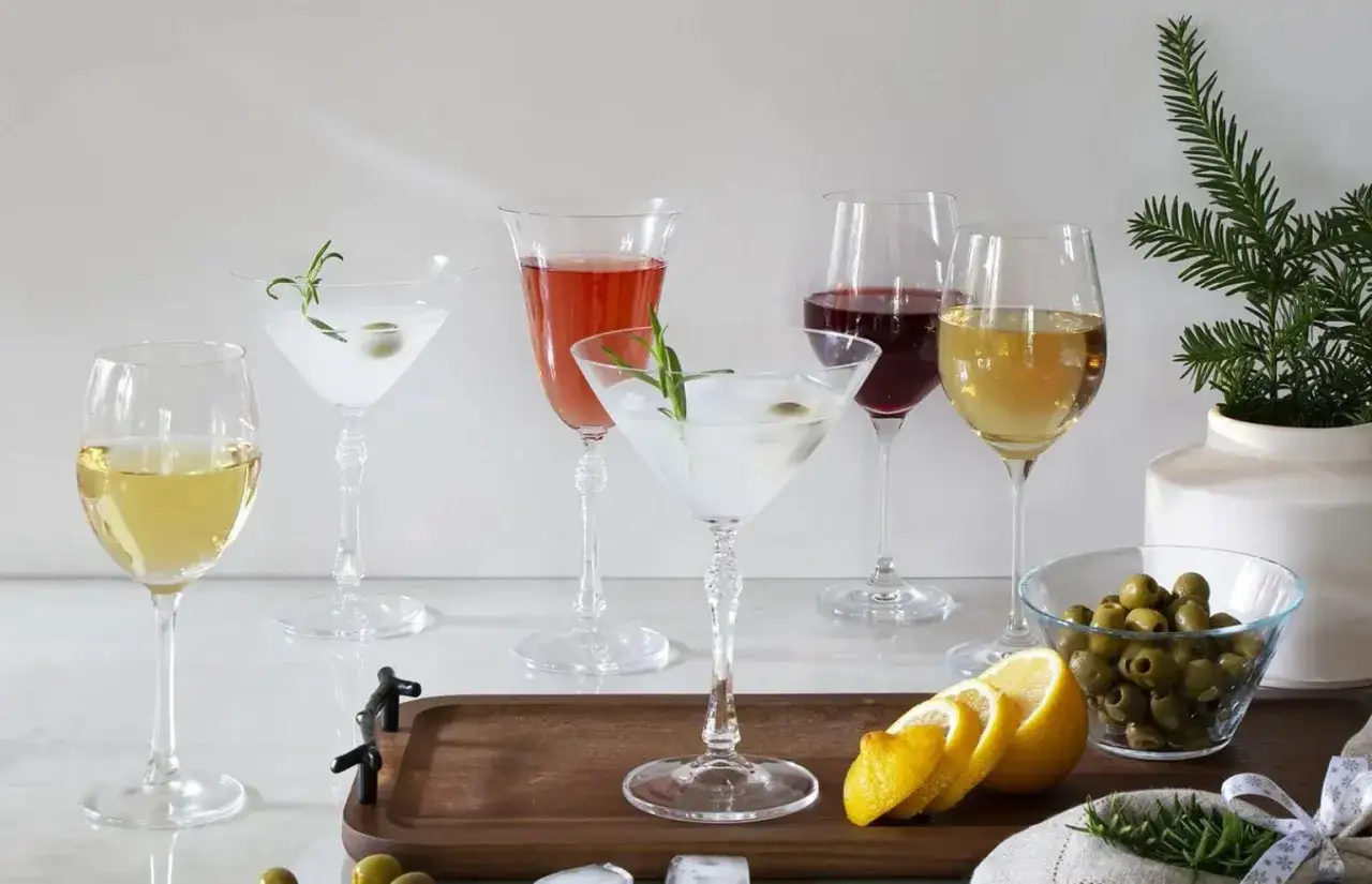 Eleganckie kieliszki z martini i winem, ozdobione gałązkami rozmarynu i oliwkami, gotowe na przyjęcie.