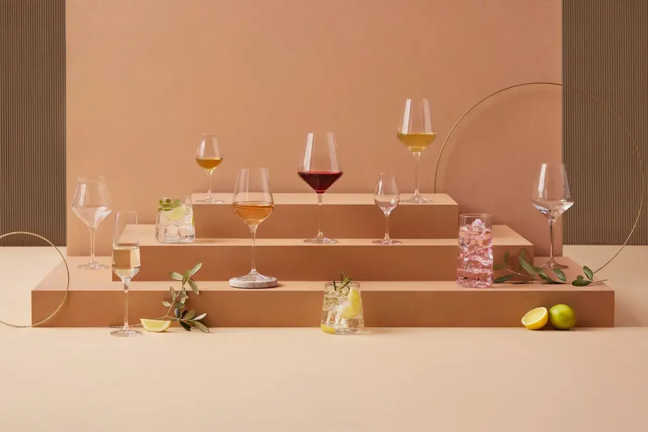 Elegancka **setka** kieliszków z różnymi napojami, od wina po drinki, na schodkowym tle.