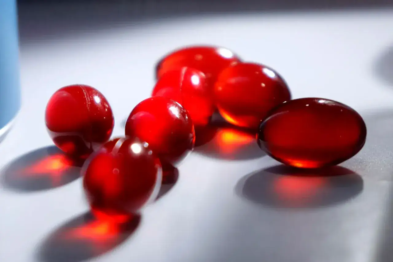 Rote Kapseln, die Astaxanthin enthalten k&ouml;nnten. M&ouml;gliche astaxanthin nebenwirkungen sind selten, aber bei Einnahme zu beachten.