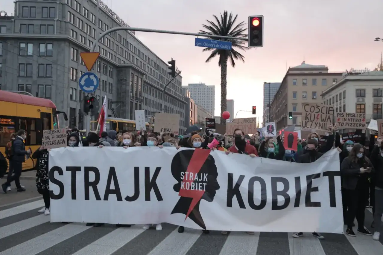 Uczestnicy protestów Strajku Kobiet niosą transparent. Jak protesty strajku kobiet wpłynęły na poparcie PiS?