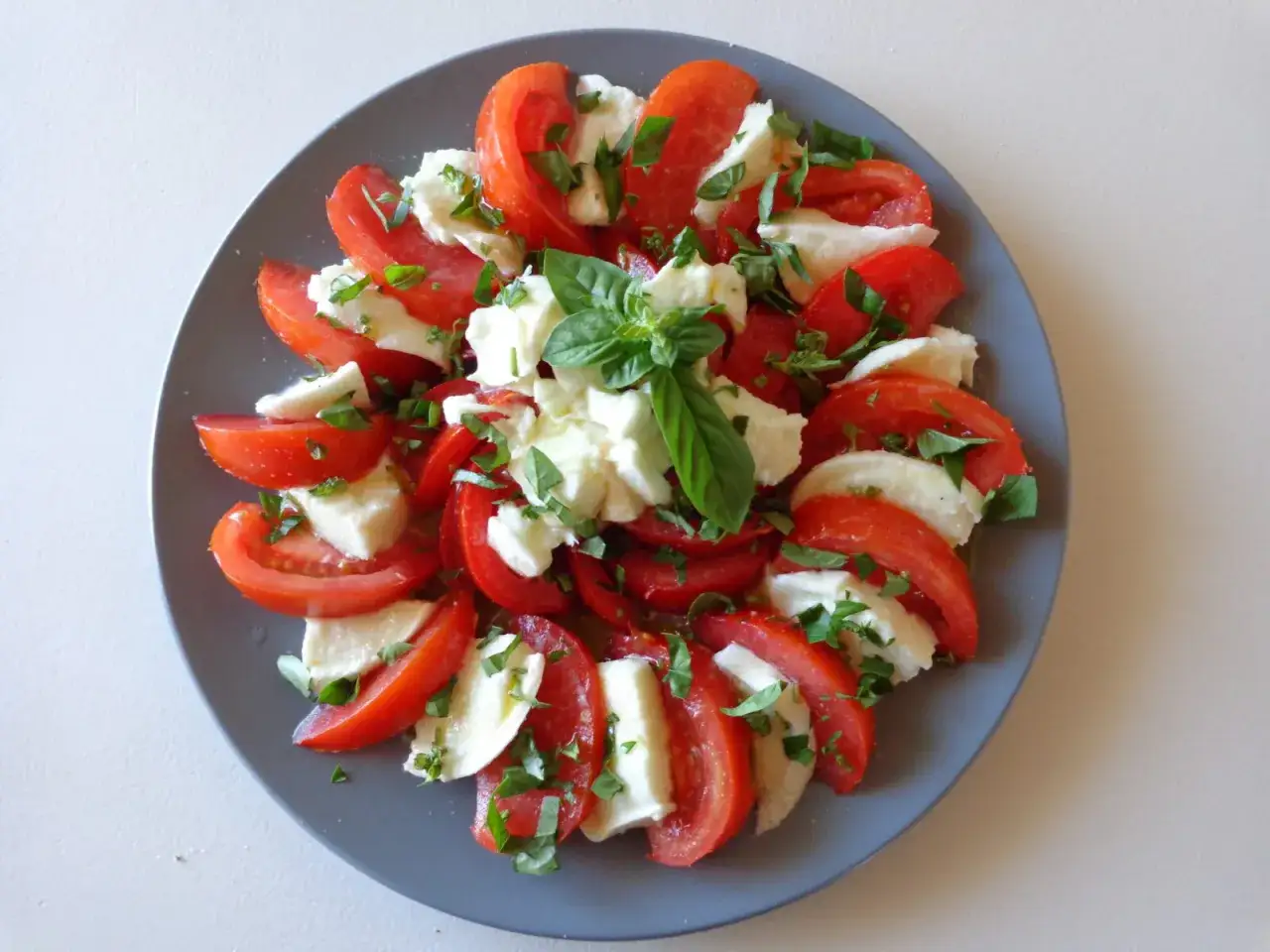 Salade Caprese : une recette tomate mozzarella simple et fra&icirc;che, garnie de basilic. Parfait pour un repas l&eacute;ger.