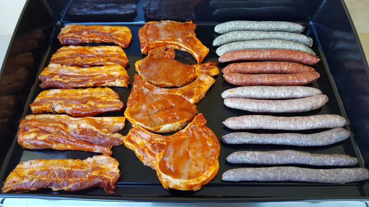 C&ocirc;telettes et lard marin&eacute;s, pr&ecirc;ts pour le barbecue. Quelle viande au barbecue pour changer ? Des saucisses vari&eacute;es compl&egrave;tent ce festin.