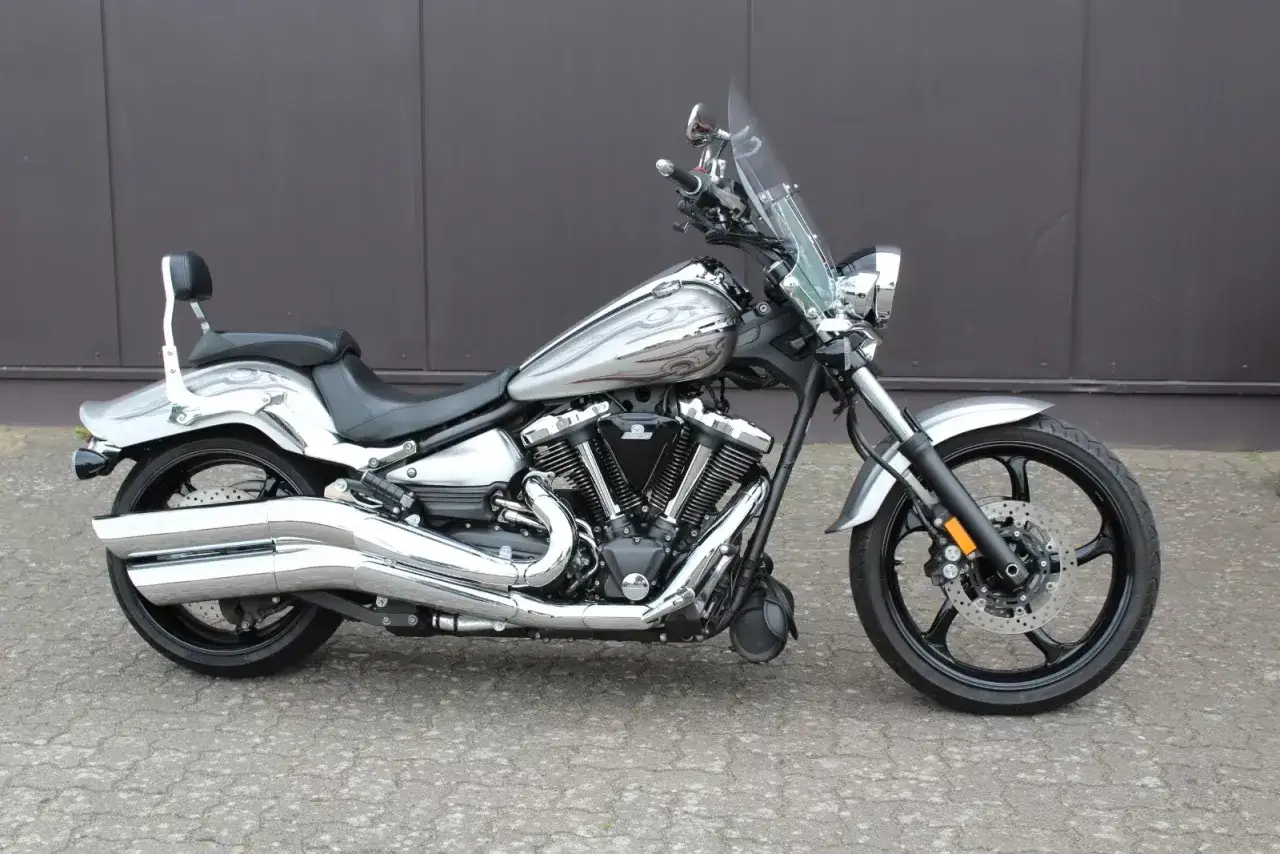 Srebrny motocykl z chromowanymi elementami i ozdobnym malowaniem na baku. Ten bryś motocykle wygląda imponująco.