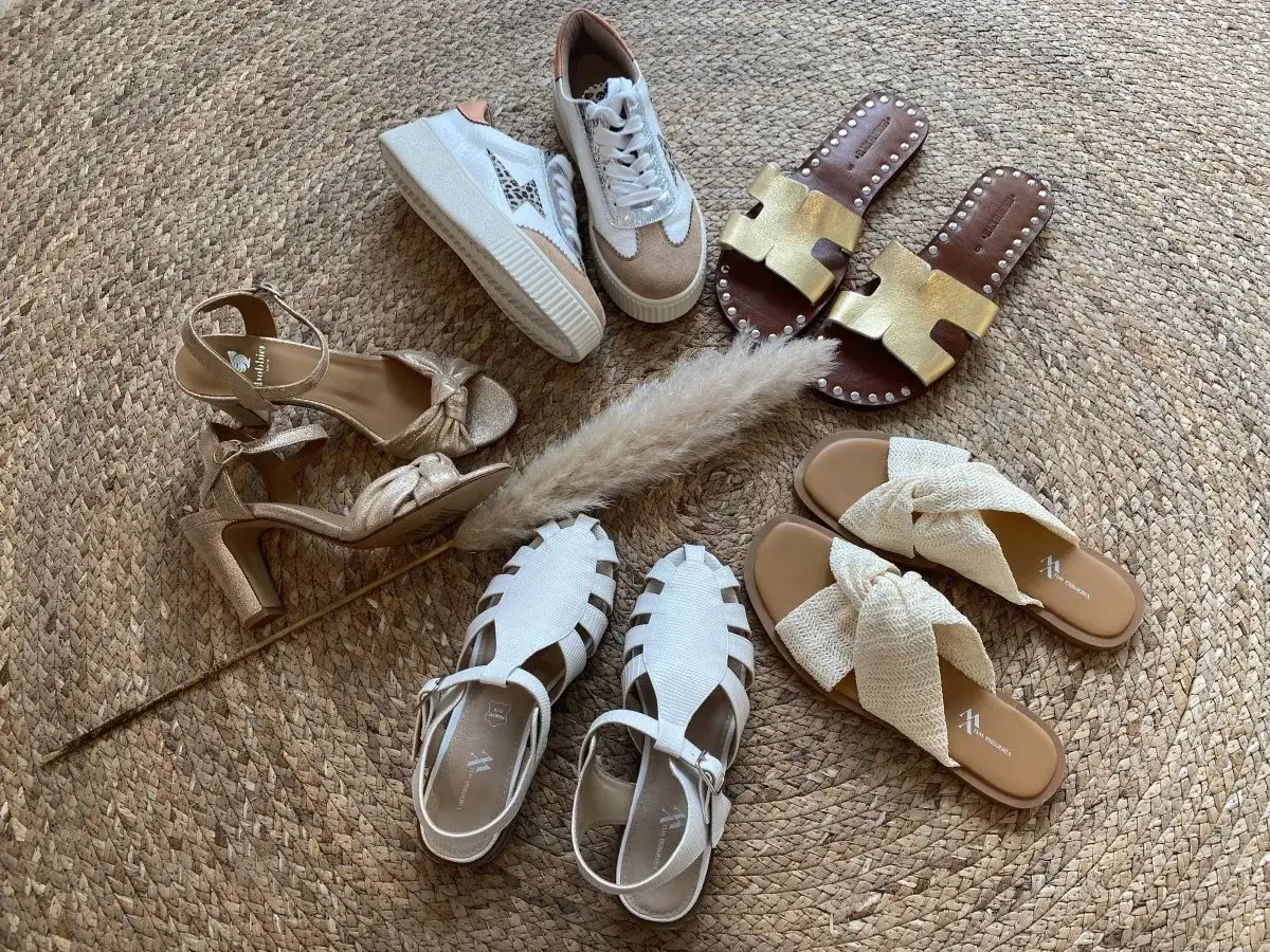 Quelques paires de chaussures parfaites pour le printemps : sandales dorées, baskets tendance, mules en paille et spartiates blanches.