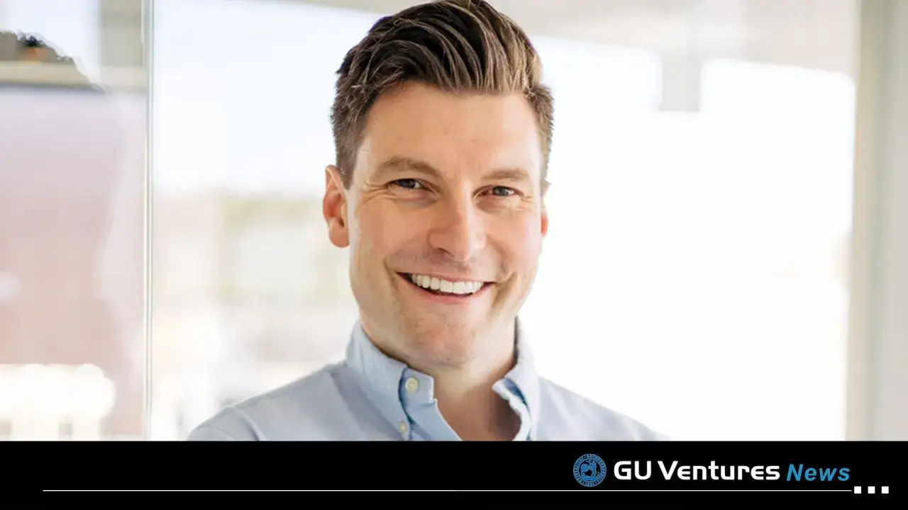 Erik Gatenholm, en glad man med kort brunt h&aring;r, ler mot kameran i en ljusbl&aring; skjorta.