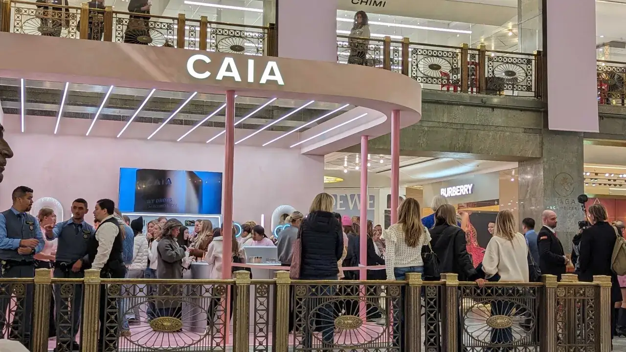 En folkmassa samlas vid en rosa CAIA pop up-butik i ett k&ouml;pcentrum.