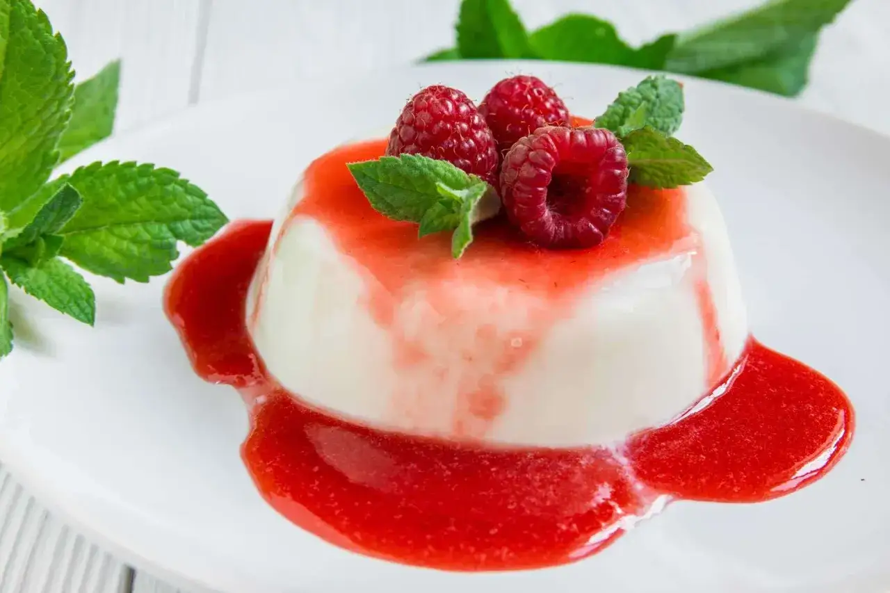 Ein cremiges Panna Cotta mit Himbeersauce und frischen Beeren, ein köstliches rezept panna cotta original italienisch.