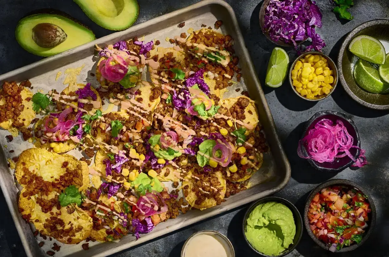 En bricka med tacos, toppade med köttfärs, lök, majs, kål och avokado. Gott till tacos!