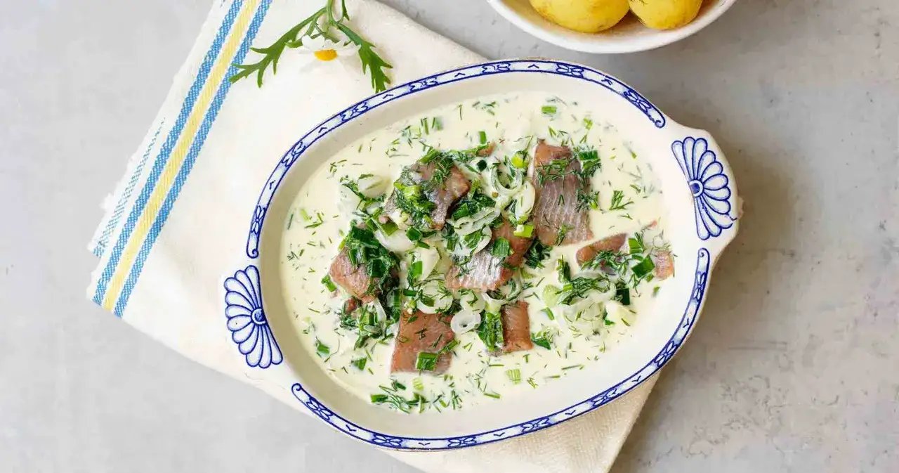 Matjessill i gr&auml;ddig s&aring;s med dill och l&ouml;k, ett klassiskt recept.