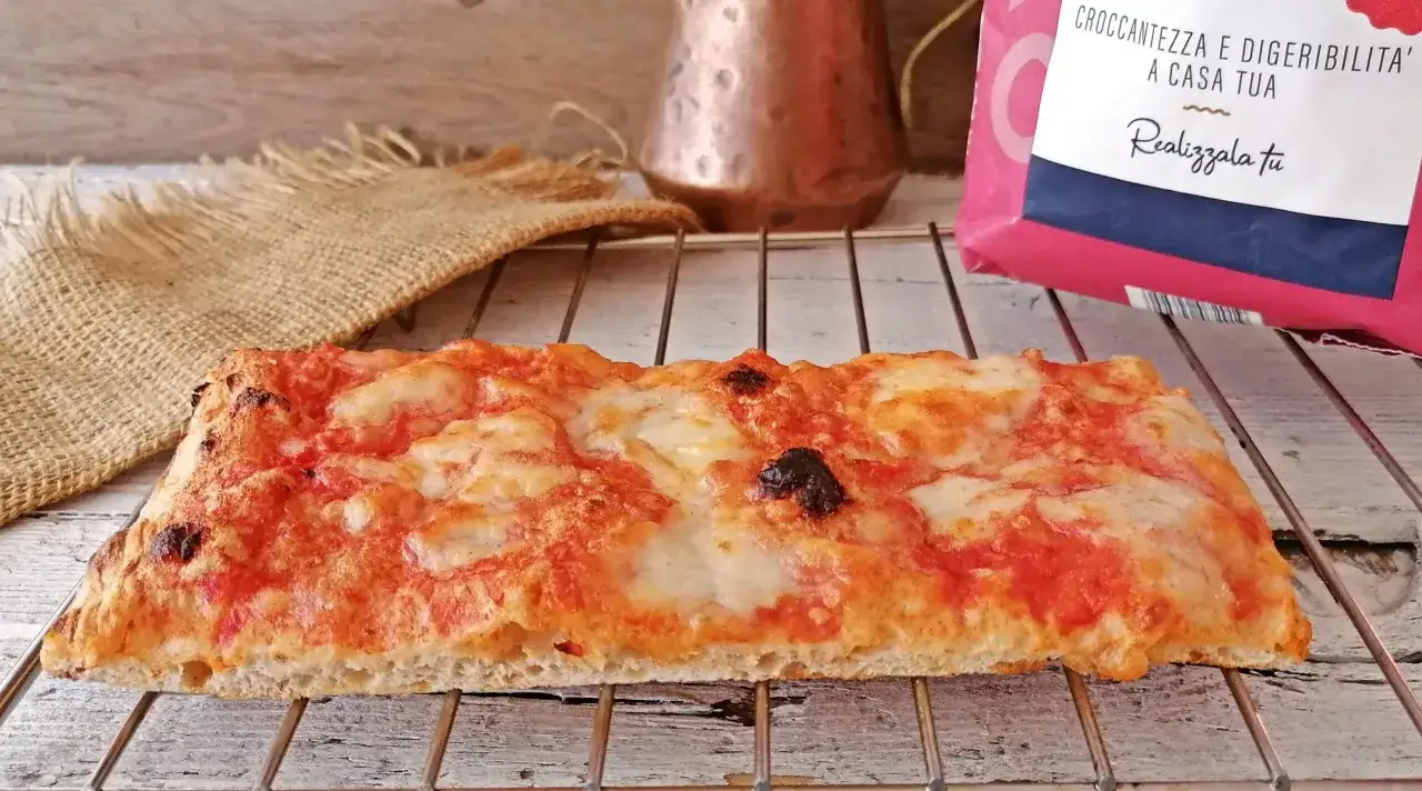 Lingue di pizza croccanti e dorate, con pomodoro e mozzarella filante, pronte per essere gustate.