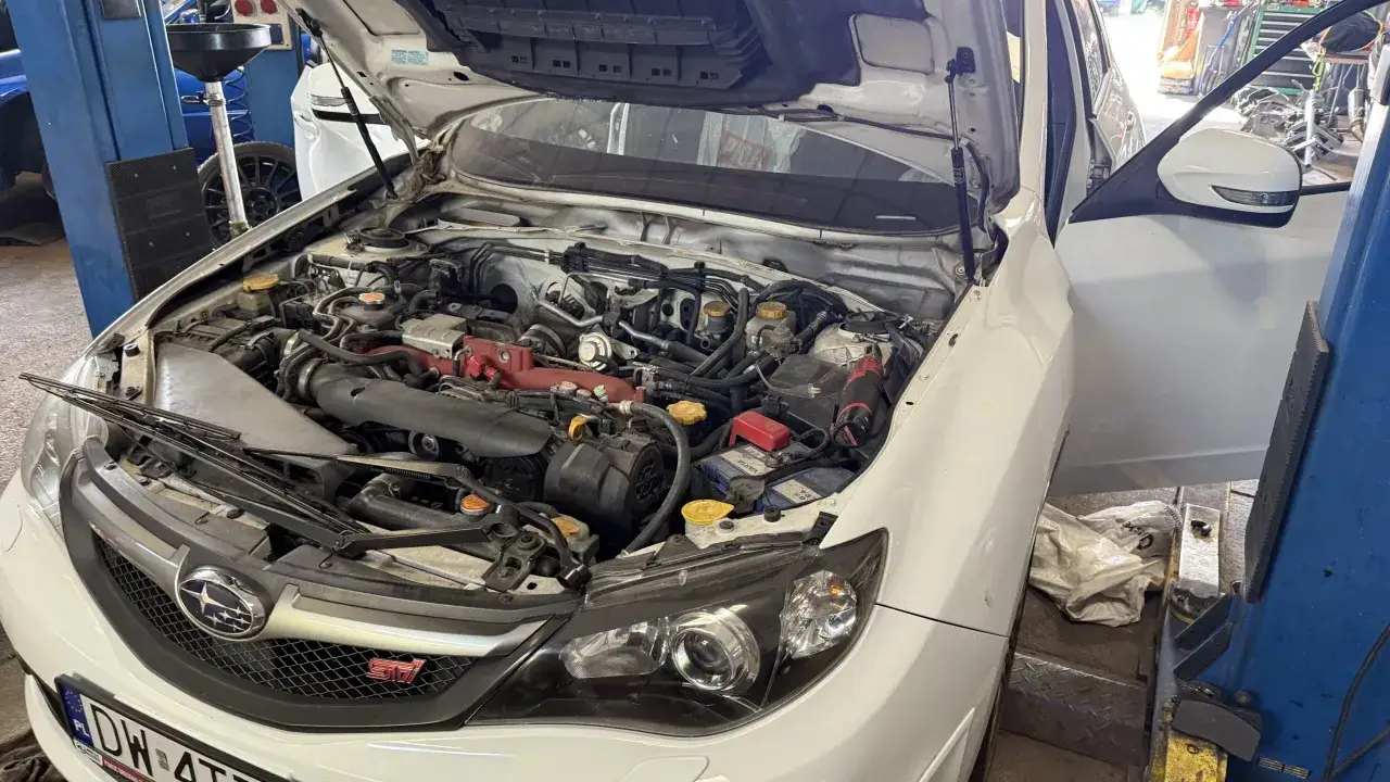 Biały Subaru z otwartą maską w warsztacie. Zastanawiasz się, ile kosztuje instalacja gazowa?