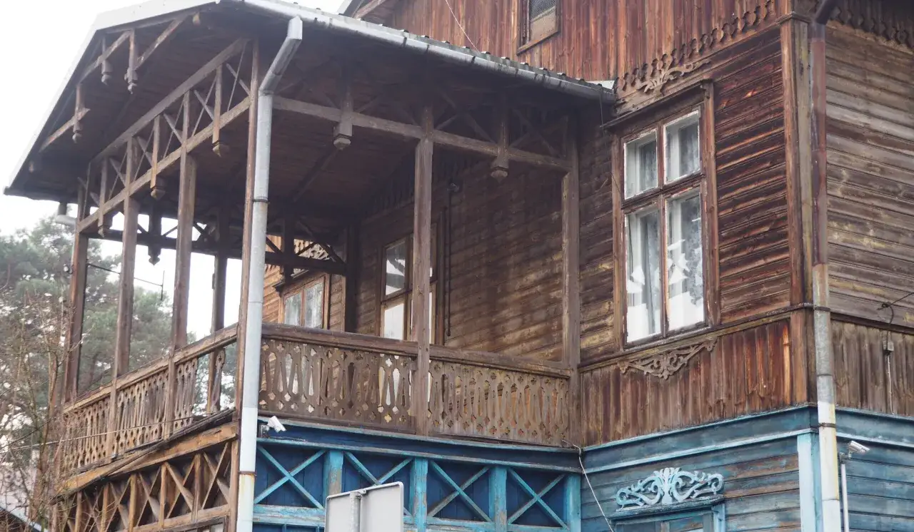 Drewniana weranda z ażurową balustradą, część starego domu w mieście nad Świdrem.