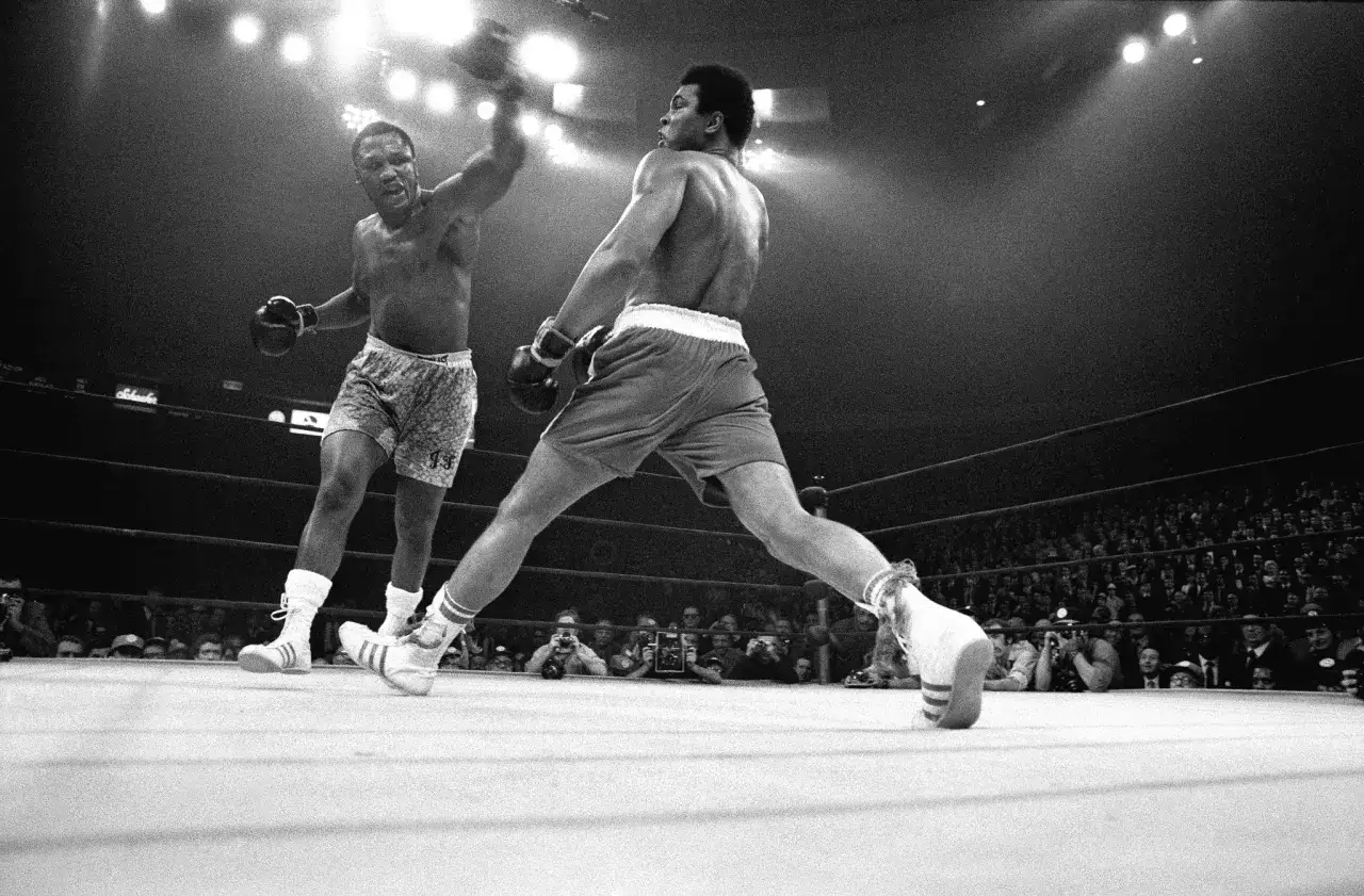 Two boxers in a ring, one throwing a punch, the other moving with grace, truly embodying 